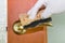 A woman`s hand in a rubber glove wipes the door handle with a sponge. Topic disinfection of door handles in an apartment, office d