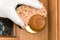 A woman`s hand in a rubber glove wipes the door handle with a sponge. Topic disinfection of door handles in an apartment, office d