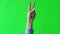 Woman`s hand show a gesture of peace. Green screen studio