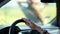 Woman\'s hand sliding on car\'s steering wheel
