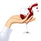 Woman`s hand with splashing red wine in the transparent wine-gla