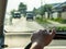 A woman`s hand on the steering wheel, behind a dirty windshield, the outskirts of the village, selective focus