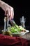 A woman`s hand is stirring a salad of Peking cabbage