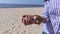 Woman`s hand with stones on beach near sea