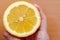 A woman`s hand takes a slice of organic fresh yellow lemon on a wooden cutting board. Slices of lemon on a board on a green