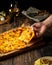 Woman`s hand taking a piece of Belgian style four cheeses pizza, flammekeuche