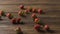 A woman\'s hand throws some red ripe wet strawberries, a handful of berries on a wooden table. Tracking slow motion video