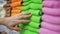 A woman`s hand touches multi-colored terry towels