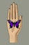 Woman`s hand with a violet butterfly sitting on her palm