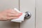 Woman`s hand wipes the chrome-plated handle of interior door with a damp cloth. Antiseptic treatment of living quarters