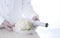 Woman`s hand wrapping organic cauliflower on marble table in white kitchen
