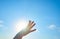 Woman`s hand with a yellow butterfly, on a background of blue sky and the sun. Freedom, ok, happiness concept