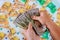 Woman`s hands count dollars on the background of euro banknotes