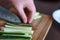 Woman& x27;s Hands Cut Cucumber Matchsticks with Santoku Knife on a Wooden Chopping Board. Salads, Maki and Temaki Sushi Rolls