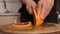 Woman`s hands cutting fresh grapefruit on kitchen.