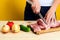 Woman\'s hands is cutting pork