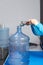 Woman's hands filling a gallon of clean water with a faucet.