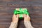 Woman`s hands give wrapped valentine holiday handmade present in craft paper with green ribbon. Present box, decoration of gift o