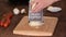 Woman`s hands grate cheese on a metal grater.