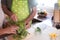 The woman`s hands guide her husband`s hands to cut and clean the broccoli. Stay together in the kitchen and prefer healthy