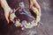 Woman`s hands hold foam wreath with sprint flowers