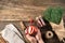 A woman`s hands hold a glass of mulled wine next to a bouquet of pine branches, mittens and berries on a wooden