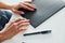 Woman`s hands holding black colored notepad that lying on the table