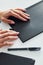 Woman`s hands holding black colored notepad that lying on the table