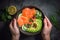 Woman& x27;s hands holding a bowl with salmon and avocado salad, top view. Generative AI