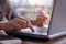 Woman`s hands holding credit card and typing on the keyboard of laptop for shopping online. Pays for purchase