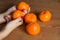 A woman`s hands holding some mandarins on wood background. selective focus