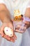 Woman`s hands holding transparent plastic cup with chocolate mousse, decorated with bunny shaped cookie