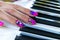 Woman`s hands on the keyboard of the piano closeup. Hands musician playing the piano. Top view. Hands pianist playing music on th