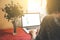 Woman`s hands on the laptop. Beautiful flowers and linen tablecloth. Perfect working place at home. Freelance concept. Searching