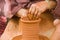 WomanÂ´s hands making a clay vase with a potters wheel. Close up.