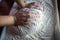 Woman`s hands with manicured nails work with dough in the kitchen