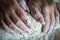 Woman`s hands with manicured nails work with dough in the kitchen