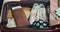 Woman`s hands packing suitcase for a journey on the bed at home. Travel preparations.