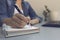 Woman`s hands with pen writing on notebook. Modern grey office d