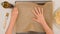 Woman`s hands placing parchment paper onto a baking pan, close up baking process