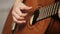 Woman\'s hands playing acoustic guitar.