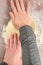 Woman’s hands pressing and spreading raw pizza dough on a clear plastic mat, preparation for baking