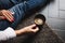 Woman`s hands with red nails holding cup of coffee on knees while sitting on the flour