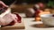 Woman`s hands slicing beet on wooden cutting board