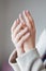 Woman`s hands stretch up on a light gray background, classic manicur