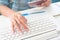 Woman`s hands using laptop computer and holding passport book, B