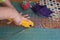 Woman`s hands using a rotary cutter to cut leftover quilting fabric for hand sewn face masks