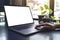 A woman`s hands using and touching laptop touchpad with blank white desktop screen with coffee cup on wooden table in cafe