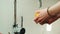 Woman`s hands wash a lemon under the tap with water