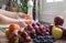 Woman`s hands washing two apricots under the water flush, assortment of fresh fruit in kitchen, bright light from window